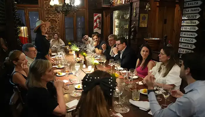 Mesa comprida com convidados durante um jantar no terraço